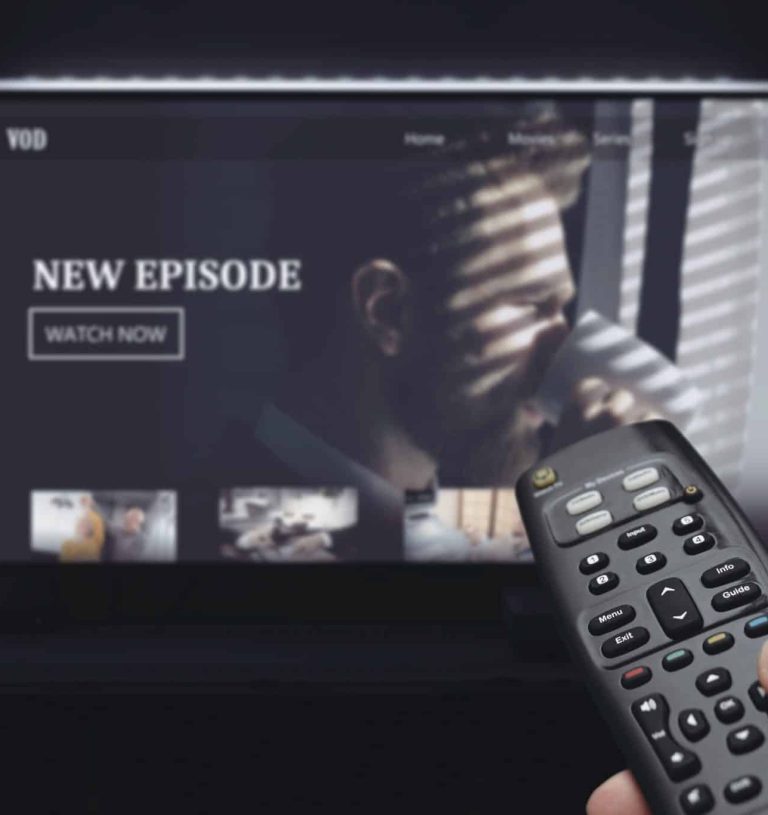 VOD service on television. Man watching TV, streaming service, video on demand, remote control in hand.